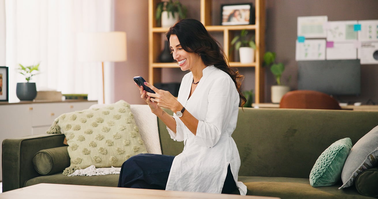 Funny, phone or happy woman on couch laughing at comedy video on social media app for humor. Relax, house or female person on sofa with smile, notification or silly meme joke for mobile entertainment.